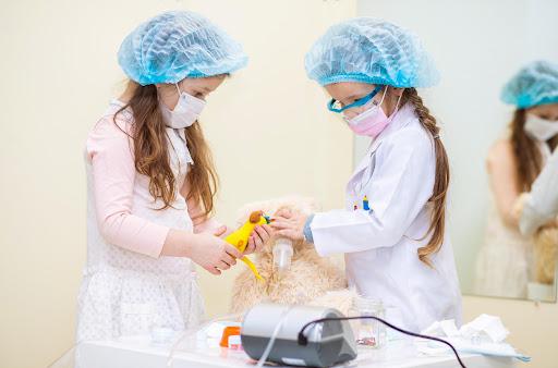 two girls wearing ppe playing with a medical device