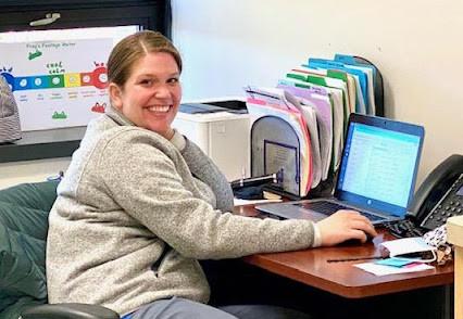 a woman smiling at a computer